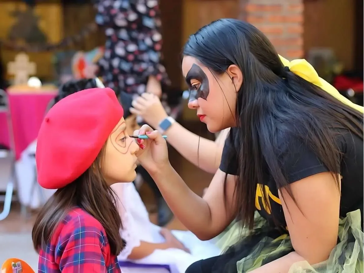 Animadora pintando la carita de una niña